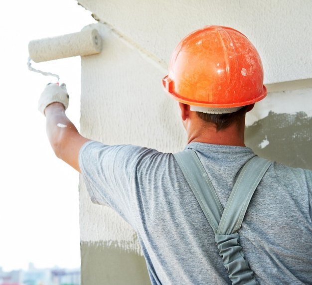 Painter rolling an exterior wall